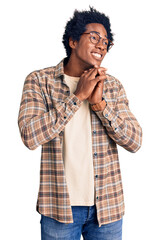 Canvas Print - Handsome african american man with afro hair wearing casual clothes and glasses laughing nervous and excited with hands on chin looking to the side