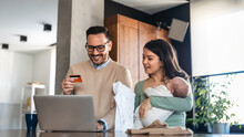 Young Family, Parents With Baby Shopping Online On Laptop With Credit Card At Home. Online Shopping