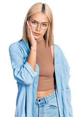 Canvas Print - Beautiful young blonde woman wearing glasses thinking looking tired and bored with depression problems with crossed arms.