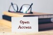 © Debalina - White card with the note Open Access on desk. Selective focus, open online access of academic information and research publications.