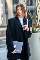 Vertical photo of a business woman on the background of an office. Office employee