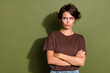 Photo of upset gloomy offended woman with bob hair dressed brown t-shirt arms crossed look empty space isolated on khaki color background