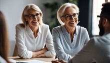 Smiling Aged Businesswoman In Glasses Looking At Colleague At Team Meeting, Happy Attentive Female