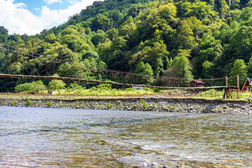 Wall Mural - travel to georgia - suspension bridge over machakhelistsqali river in mountain in adjara on sunny au