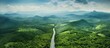 Countryside road passing through green forest and mountain seen from above Copy space image Place for adding text or design