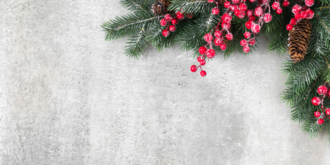 Wall Mural - Christmas holiday composition. Christmas fir tree branches, red berries on gray background. Xmas, winter, new year concept. Flat lay, top view, copy space