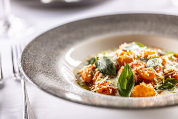 Wall Mural - Gnocchi pomodoro with mascarpone, cream, basil and parmesan, in a stylish plate on a restaurant table