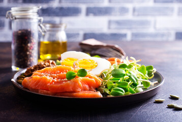 Poster - Keto diet breakfast. Salt salmon salad with greens, cucumbers, eggs and avocado.