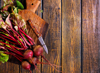 Canvas Print - fresh beets on cutting board, set on wooden table viewed from above