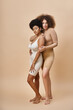© LIGHTFIELD STUDIOS - confident multicultural body positive women in underwear standing on beige, natural plus size beauty