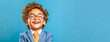 laughing boy in managerial suit with tie on blue background, banner with copy space