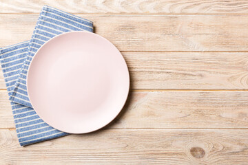 Sticker - Top view on colored background empty round pink plate on tablecloth for food. Empty dish on napkin with space for your design