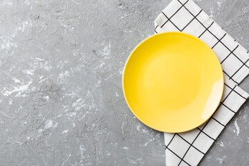 Sticker - Top view on colored background empty round yellow plate on tablecloth for food. Empty dish on napkin with space for your design