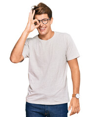 Wall Mural - Handsome caucasian man wearing casual clothes and glasses doing ok gesture with hand smiling, eye looking through fingers with happy face.