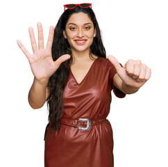 Wall Mural - Brunette young woman wearing dress and sunglasses showing and pointing up with fingers number six while smiling confident and happy.