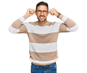 Poster - Handsome man with beard wearing casual clothes and glasses smiling pulling ears with fingers, funny gesture. audition problem