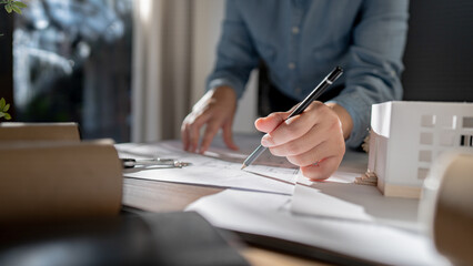 Fototapete - Architects interior designer hands working with Blue prints and documents for a home renovation for house design.