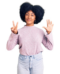 Poster - Young african american girl wearing casual clothes showing and pointing up with fingers number seven while smiling confident and happy.