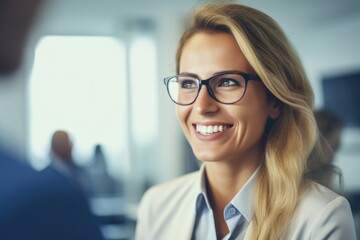 Poster - A woman with glasses smiling directly at the camera. Suitable for various professional and personal uses