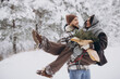 © anatoliycherkas - Cute young couple in love with pine bouquet spending time on Valentine's day in snowy winter forest in mountains