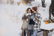 © anatoliycherkas - Happy beautiful couple resting and drinking hot tea in the forest in winter in the mountains