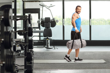 Wall Mural - Man with a sports bag walking in a gym