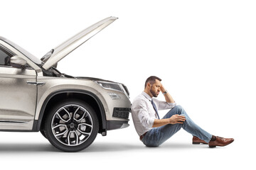 Wall Mural - Stressed young man sitting next to his broken car