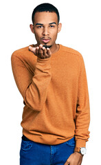 Wall Mural - Young african american man wearing casual clothes looking at the camera blowing a kiss with hand on air being lovely and sexy. love expression.