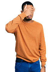 Wall Mural - Young african american man wearing casual clothes covering eyes with hand, looking serious and sad. sightless, hiding and rejection concept