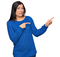 Canvas Print - Young hispanic woman wearing casual clothes pointing aside worried and nervous with both hands, concerned and surprised expression