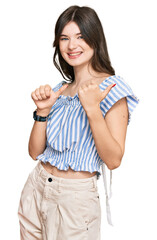 Canvas Print - Young beautiful caucasian girl wearing casual clothes pointing to the back behind with hand and thumbs up, smiling confident