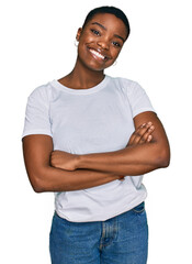 Wall Mural - Young african american woman wearing casual white t shirt happy face smiling with crossed arms looking at the camera. positive person.