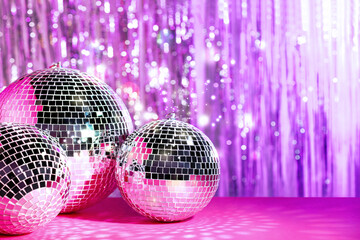 Canvas Print - Shiny disco balls on table against foil party curtain, space for text. Bokeh effect