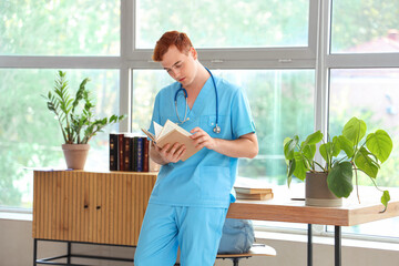 Poster - Male medical student reading book in library