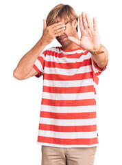 Poster - Handsome caucasian man with beard wearing casual clothes and glasses covering eyes with hands and doing stop gesture with sad and fear expression. embarrassed and negative concept.