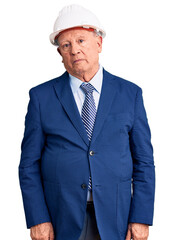 Poster - Senior handsome grey-haired man wearing suit and architect hardhat relaxed with serious expression on face. simple and natural looking at the camera.