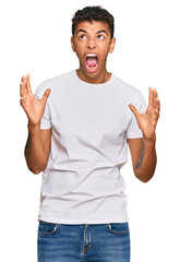 Sticker - Young handsome african american man wearing casual white tshirt crazy and mad shouting and yelling with aggressive expression and arms raised. frustration concept.