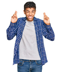 Sticker - Young handsome african american man wearing casual clothes gesturing finger crossed smiling with hope and eyes closed. luck and superstitious concept.