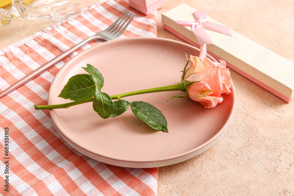 Beautiful table setting with rose and gift for Valentine's Day on beige grunge background