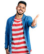 © Krakenimages.com - Young hispanic man with beard wearing casual denim jacket smiling friendly offering handshake as greeting and welcoming. successful business.
