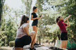 © qunica.com - Fit, active females in a city park, enjoying sports activities and training outdoors. They are stretching, warming up, and embracing a healthy lifestyle in a positive atmosphere.
