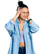 Beautiful hispanic woman wearing casual denim jacket and glasses suffering from headache desperate and stressed because pain and migraine. hands on head.