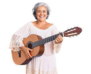 Canvas Print - Senior woman with gray hair playing classical guitar looking positive and happy standing and smiling with a confident smile showing teeth