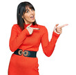 © Krakenimages.com - Young hispanic woman wearing casual clothes smiling and looking at the camera pointing with two hands and fingers to the side.