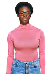Wall Mural - Young african american girl wearing casual clothes and glasses relaxed with serious expression on face. simple and natural looking at the camera.