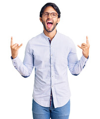 Poster - Handsome hispanic man wearing business shirt and glasses shouting with crazy expression doing rock symbol with hands up. music star. heavy music concept.