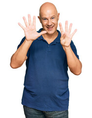 Wall Mural - Middle age bald man wearing casual clothes showing and pointing up with fingers number nine while smiling confident and happy.