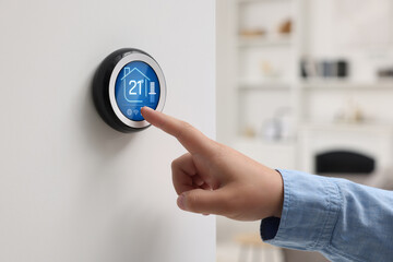 Canvas Print - Smart home system. Woman using thermostat indoors, closeup