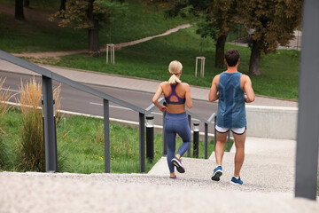 Sticker - Healthy lifestyle. Couple running down stairs outdoors, back view