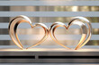 2 glittering gold and silver hearts facing each other on a broken blurred background